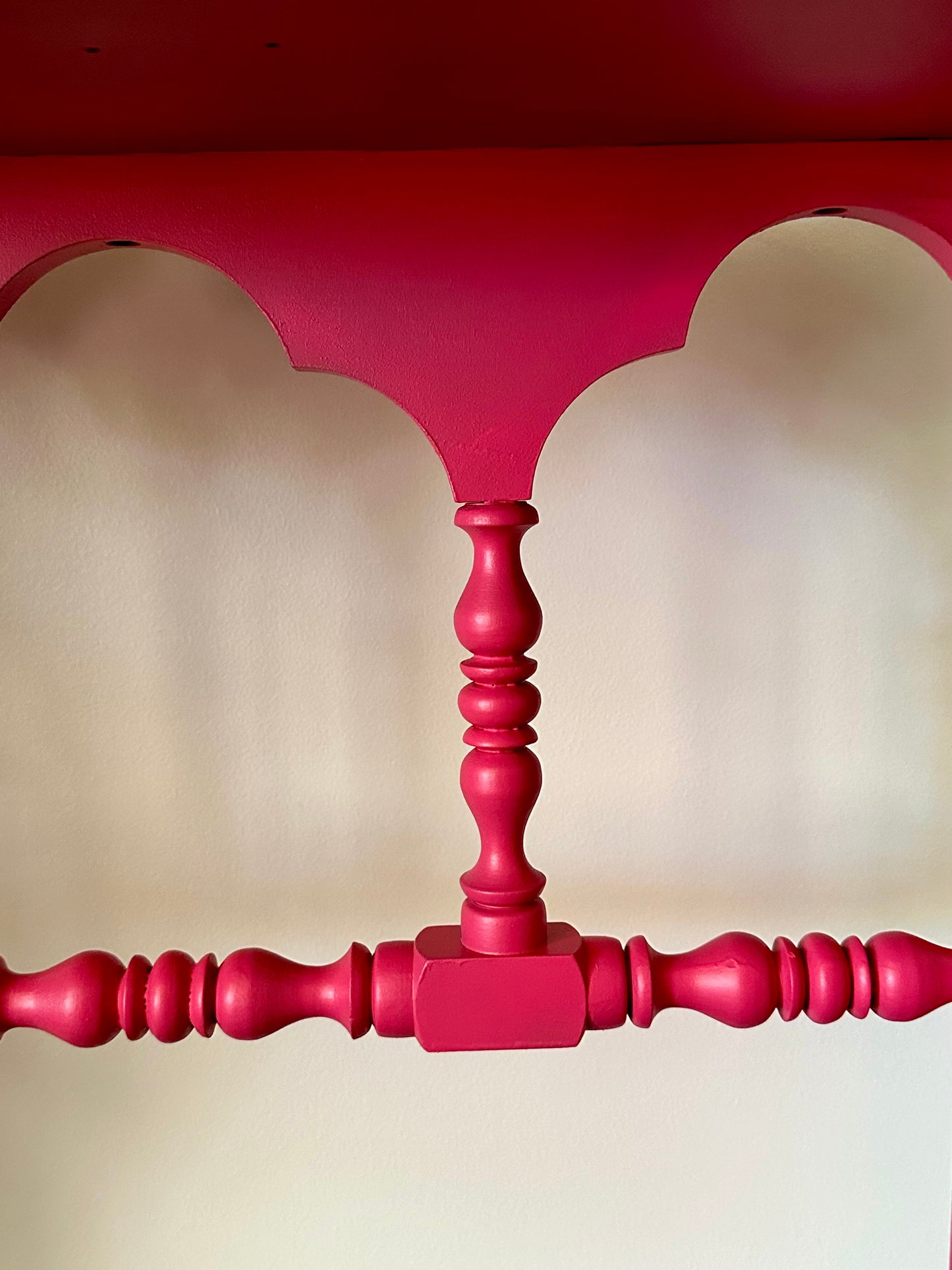 Close-up of a red wooden bed frame with a plain background