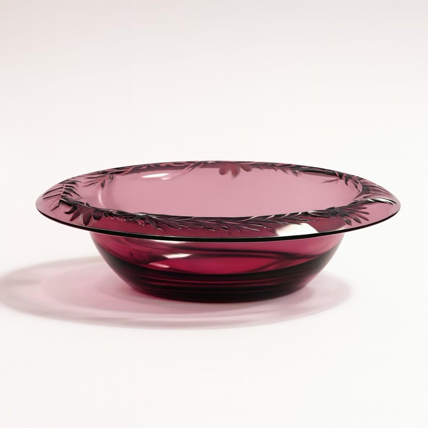 Elegant purple glass bowl with floral engravings, perfect for serving or decoration.