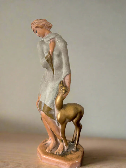 Statue of a woman holding a deer on a white background