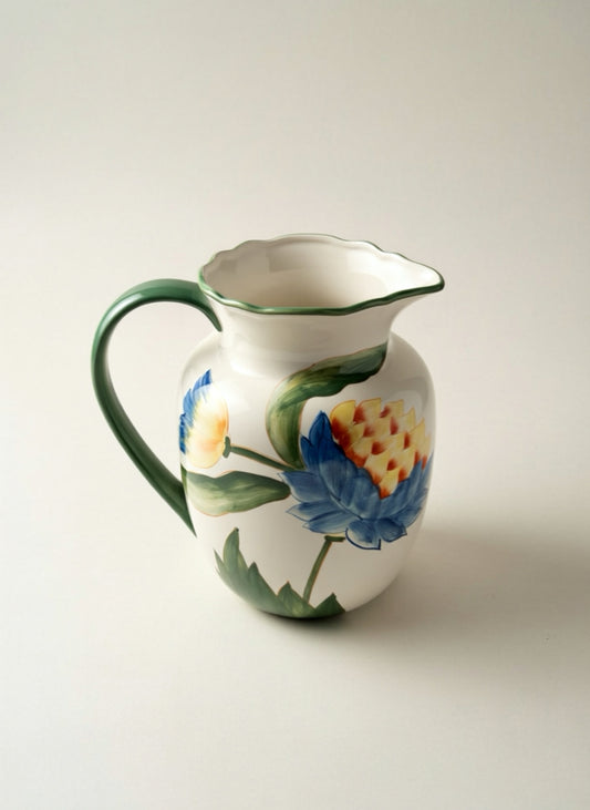 Ceramic pitcher with floral design on a plain background