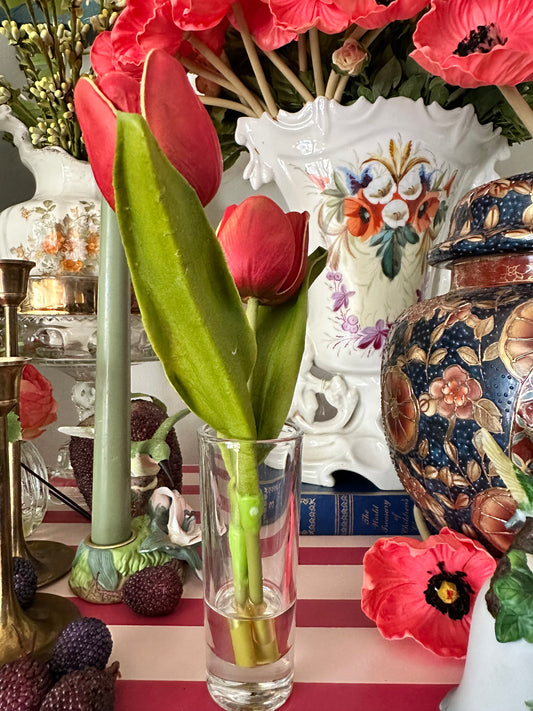 Decorative table setting with flowers, a vase, and a striped cloth.