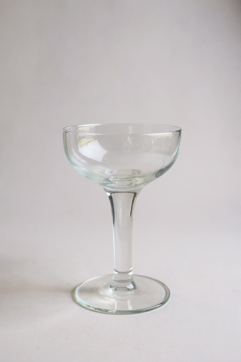 Clear glass coupe on a light gray background