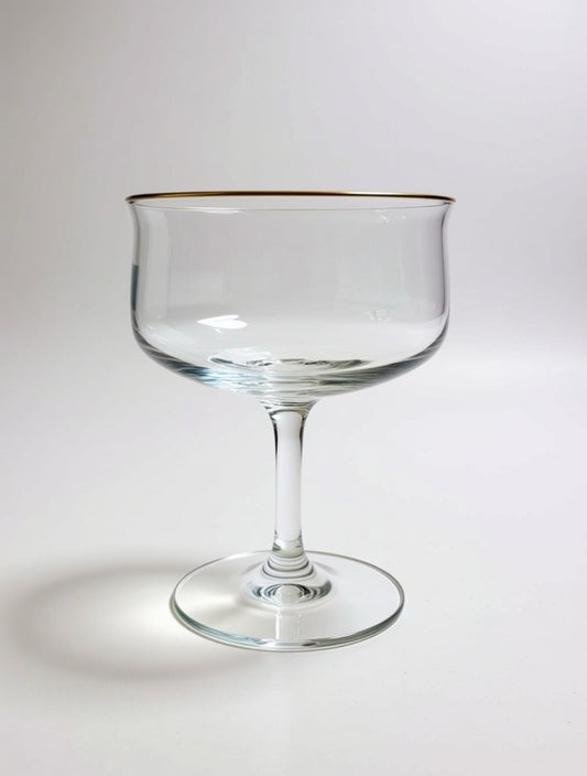 Clear glass with gold rim on a white background Image of single Lennox mid-century, modern coupe glass that belongs to a set of four in a vintage collection