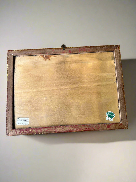 Wooden frame with a gold leaf backing on a gray background