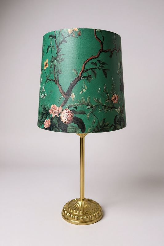 Lamp with a green floral-patterned shade on a white background