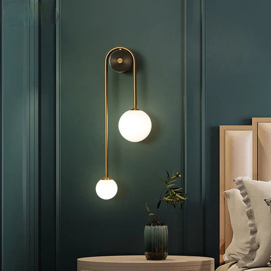 Elegant Modern Wall Lamp with Glass Ball Lampshade - LED Gold Luminaire Ideal for Home Decor, Living Room, Bedroom, and Interior Lighting Sconce with Nordic Flair on a dark green wall.