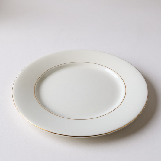 Set of ceramic plates with gold rims on a white background
