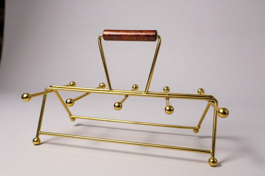 Gold metal stand with wooden handle on a gray background