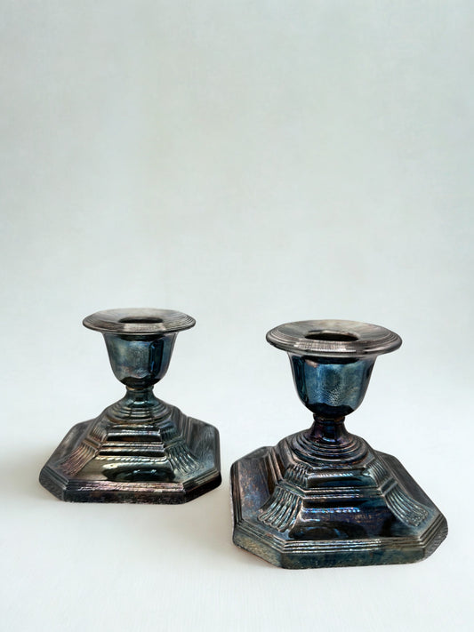 Two metallic candle holders on a white background