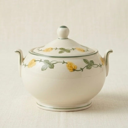 White ceramic sugar bowl with floral design on a beige background
