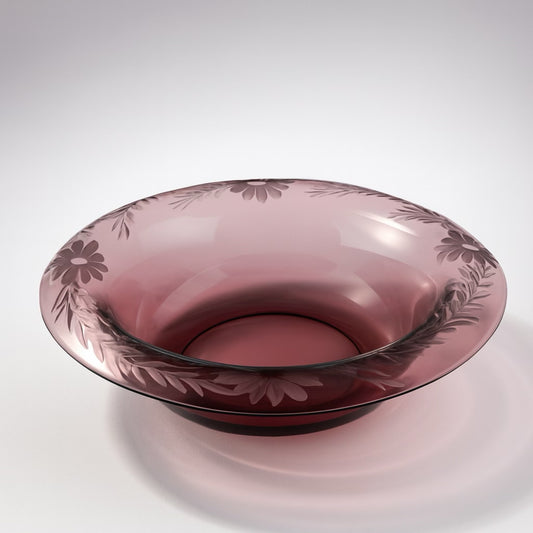 Elegant pink glass bowl featuring floral engravings, perfect for serving or as home decor.