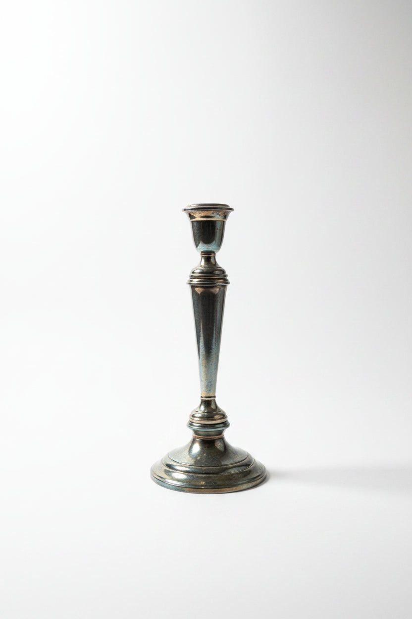 Gorham Newport silverplate convertible candelabra in single candlestick configuration showing tapered column, stepped circular base, and warm oxidized patina — arms removed, white background