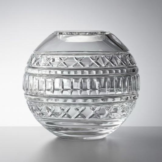 Spherical cut glass vase with etched bands and crisscross patterns, styled in soft natural light