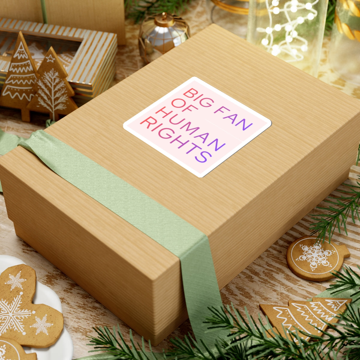 Gift box with a pastel sticker stating 'BIG FAN OF HUMAN RIGHTS', tied with a light green ribbon.