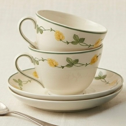 Set of ceramic cups and saucers with floral design on a light background