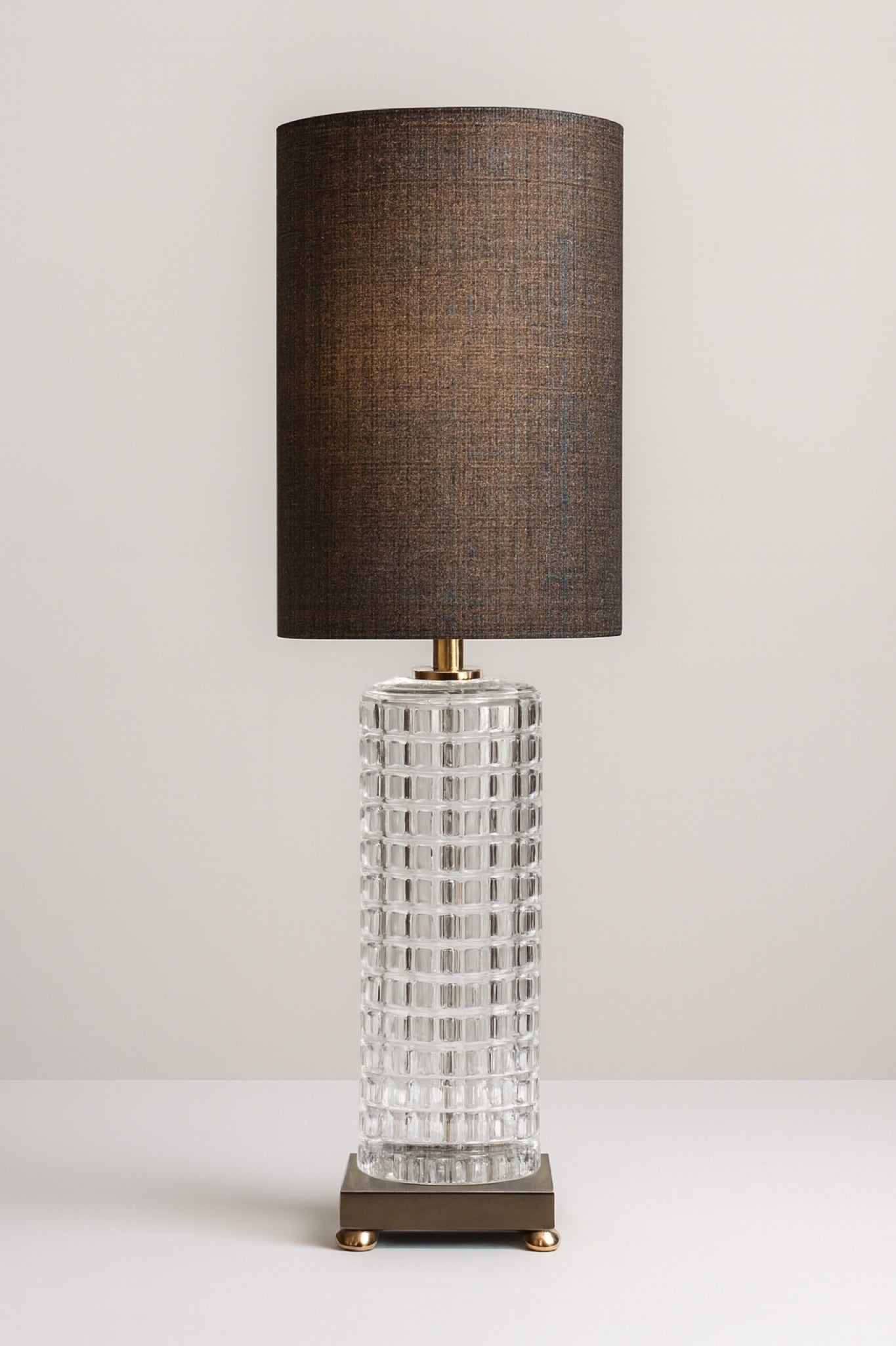 Black and gold table lamp with a textured glass base and modern metal platform, ideal for living room or bedroom lighting.