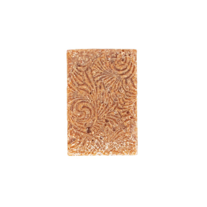 Handcrafted natural soap bar, light brown with intricate swirls, made from organic ingredients.