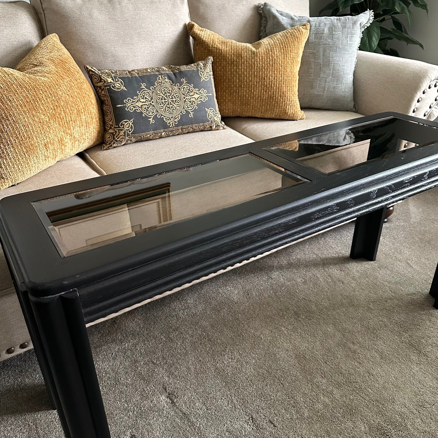 Side view of vintage black console table with fluted legs Featuring two glass table top panels