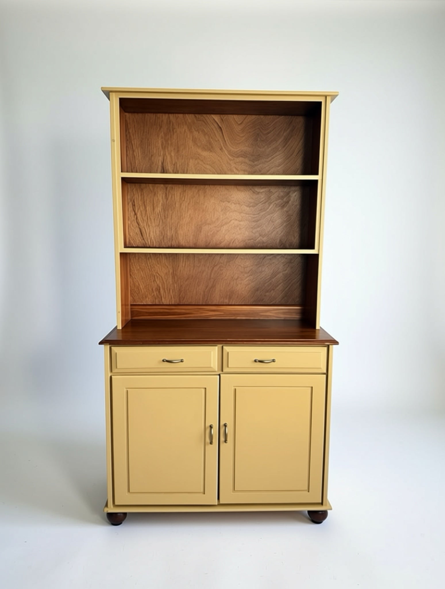Two-piece yellow breakfront with open wood-backed shelves and lower drawers, styled in a cozy living room with a sofa, artwork, and patterned rug.