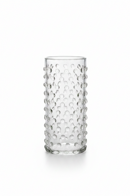 Set of 2 clear cylinder highball glasses with raised hobnail beaded texture sitting on a dark wooden tabletop, 6 inches tall.