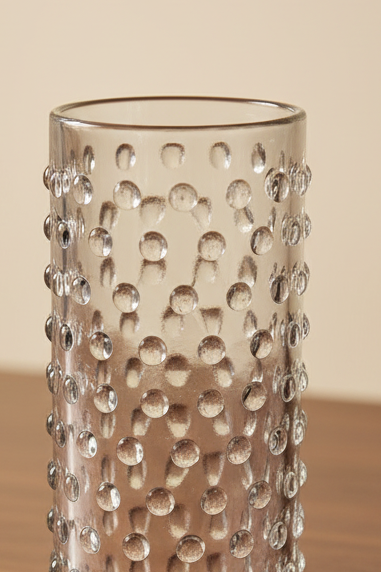 Set of 2 clear cylinder highball glasses with raised hobnail beaded texture sitting on a dark wooden tabletop, 6 inches tall. Arranged on wooden surface 
