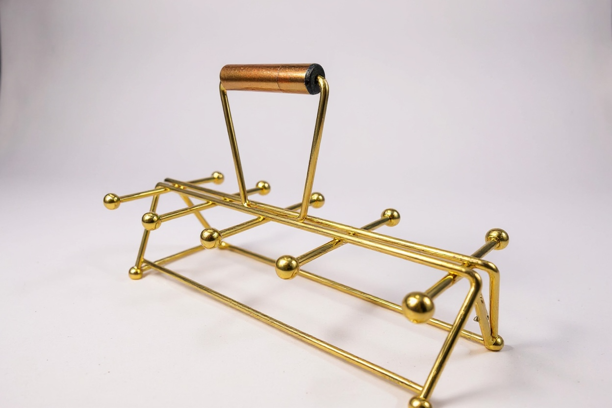 1960s mid-century modern brass beverage caddy with atomic ball-ended prongs and a dark wood handle against a crisp white background.
