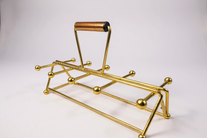 1960s mid-century modern brass beverage caddy with atomic ball-ended prongs and a dark wood handle against a crisp white background.