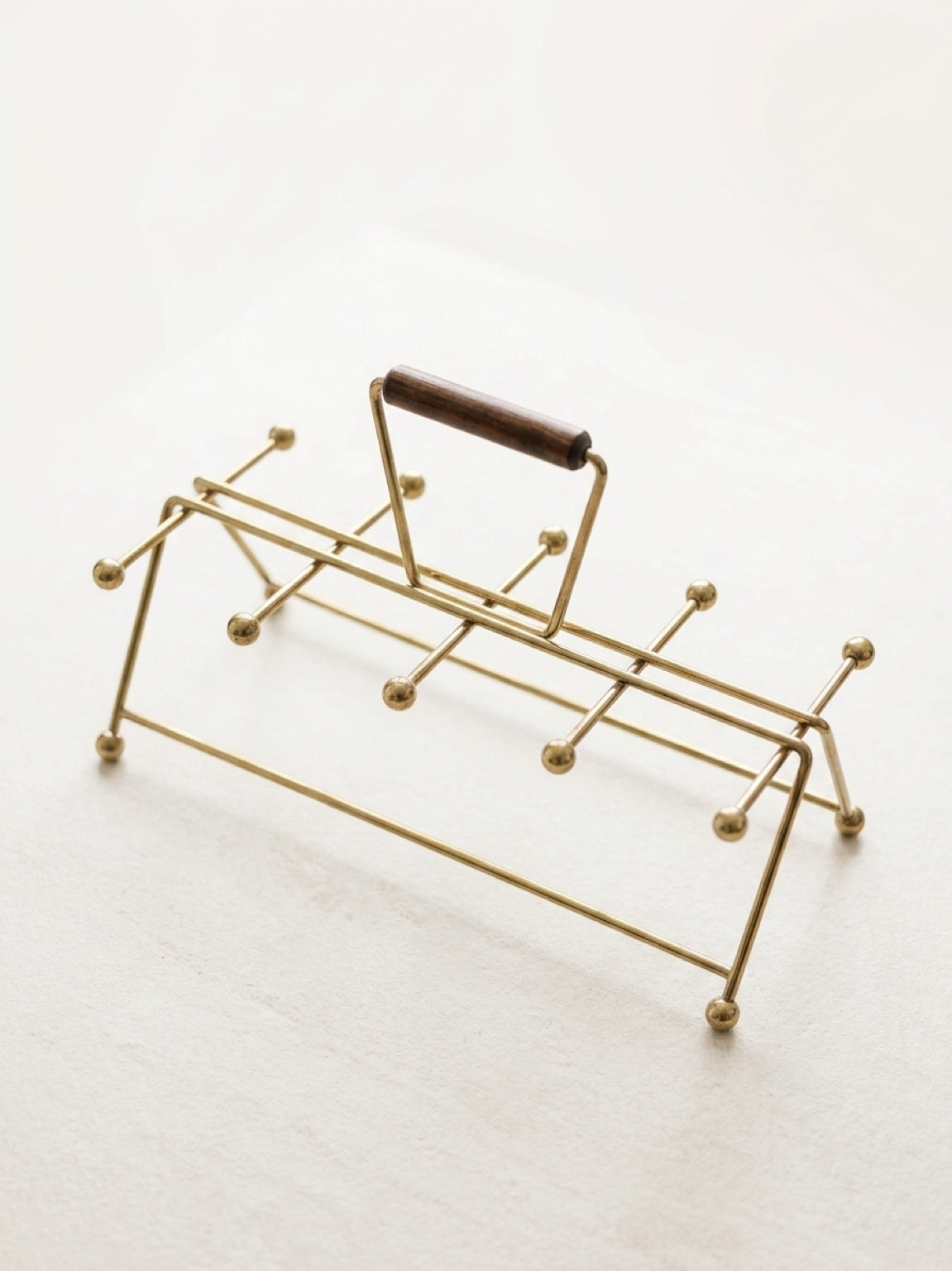 Gold vintage mid century modern atomic age drink carrier with a wooden handle on a white background