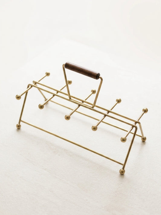 Gold vintage mid century modern atomic age drink carrier with a wooden handle on a white background