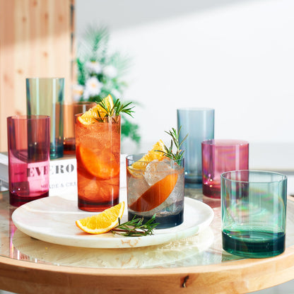 Colorful glasses with drinks and garnishes on a wooden table