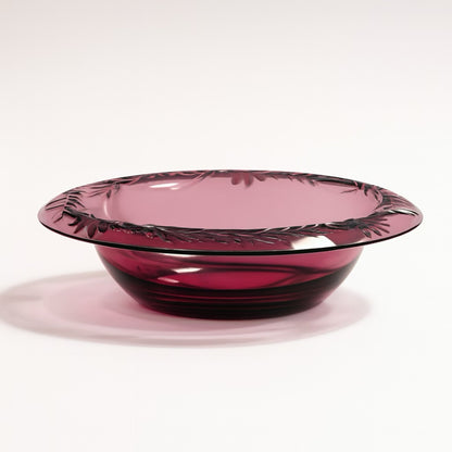 Elegant purple glass bowl with floral engravings, perfect for serving or decoration.