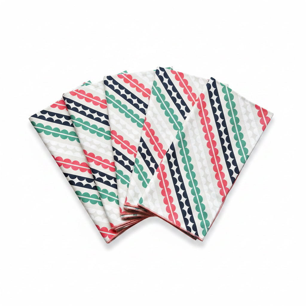 Set of four Matilda cloth napkins fanned out showing bold diagonal geometric stripe print in coral pink, teal, and navy on white 100% cotton, handmade in Georgia USA
