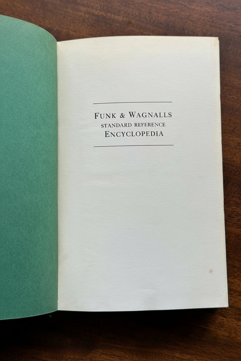  Open title page of vintage Funk and Wagnalls Standard Reference Encyclopedia showing clean off-white period paper with classic serif typography on natural wood surface