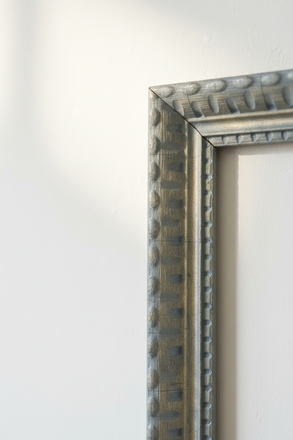 Corner detail of vintage French country carved wood frame showing tight mitered join, fluted inner trim, and distressed slate blue and gold craquelure surface patina