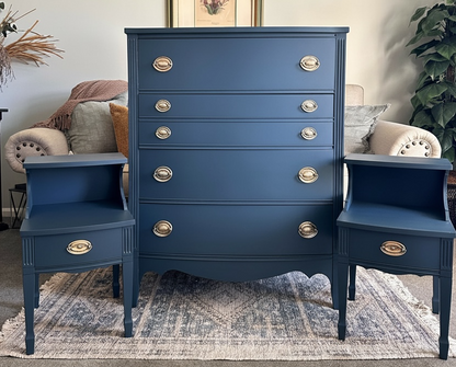 Blue dresser with matching side tables in a room with decor elements.