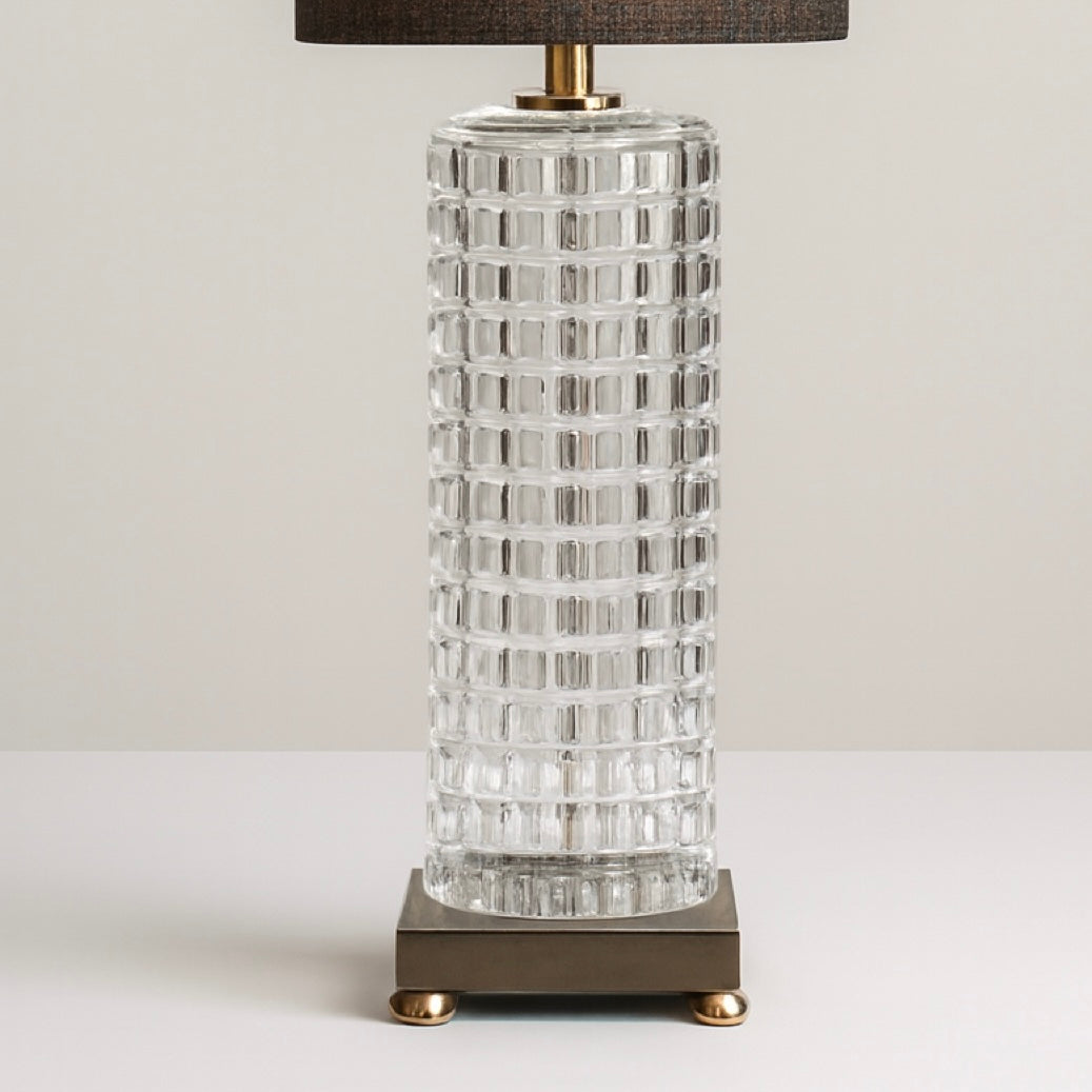 Black and gold table lamp with a textured glass base and modern metal platform, ideal for living room or bedroom lighting.