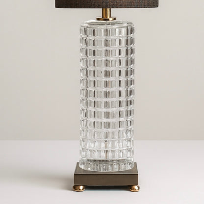 Black and gold table lamp with a textured glass base and modern metal platform, ideal for living room or bedroom lighting.