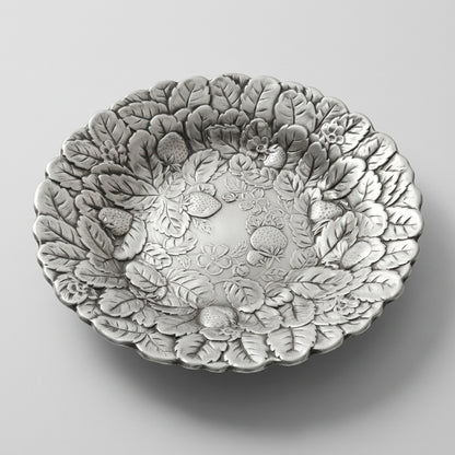 An angled profile edit of a mid century silverplate tray with an embossed berry motif serving bowl design.
