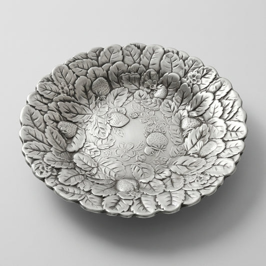 An angled profile edit of a mid century silverplate tray with an embossed berry motif serving bowl design.