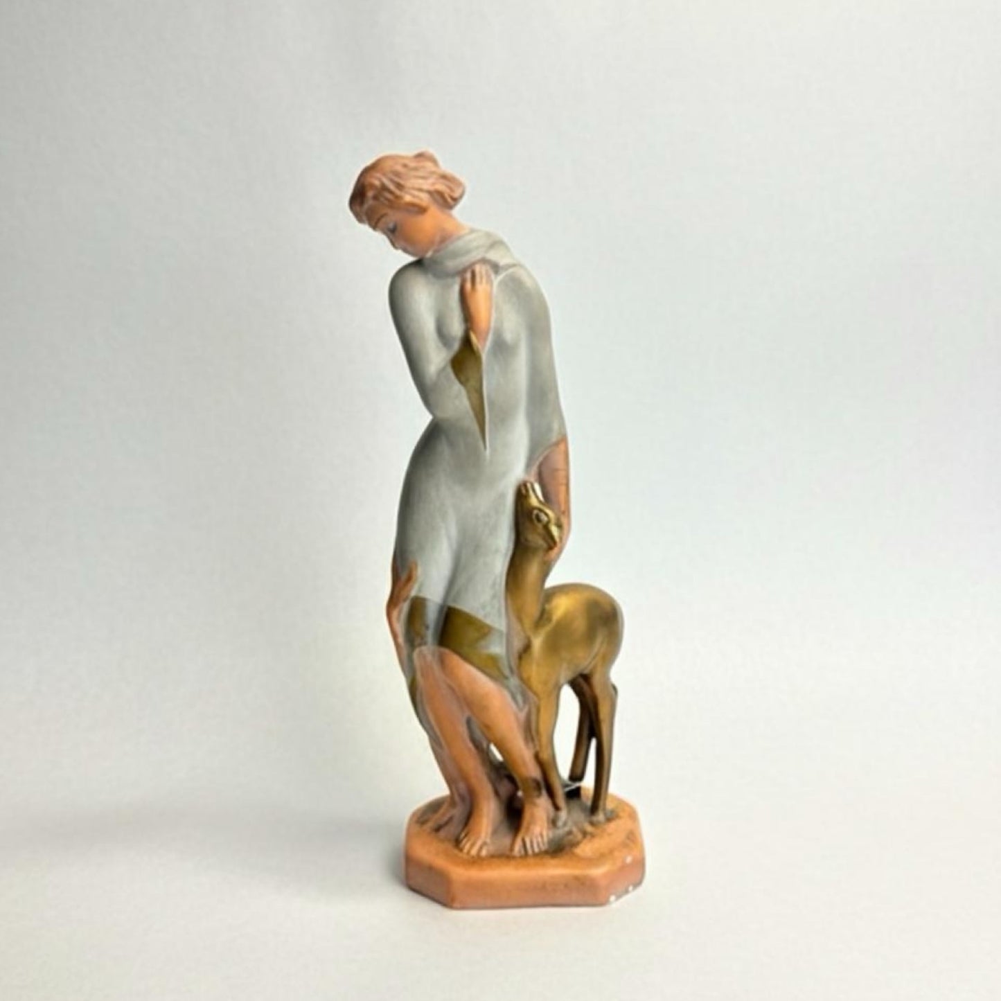 Statue of a woman with a deer on a light gray background Art Deco Goddess & Fawn Chalkware Figurine – Mid-Century Modern Sculptural Decor