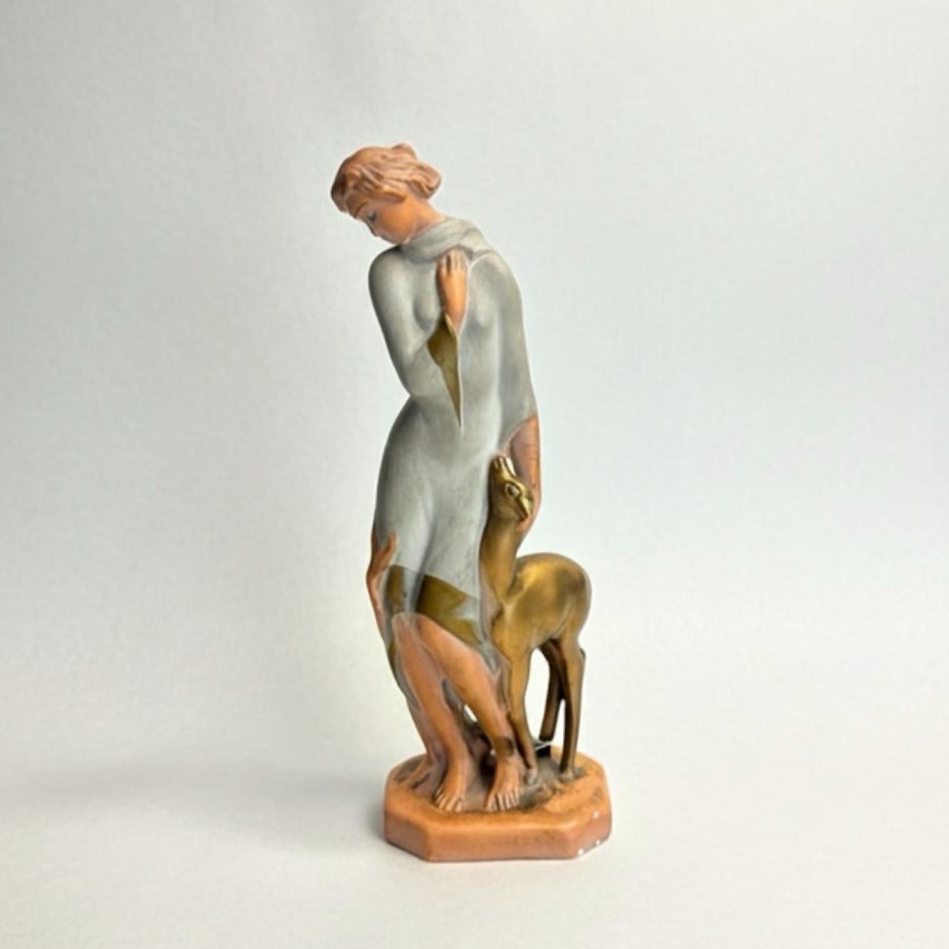 Statue of a woman with a deer on a light gray background Art Deco Goddess & Fawn Chalkware Figurine – Mid-Century Modern Sculptural Decor