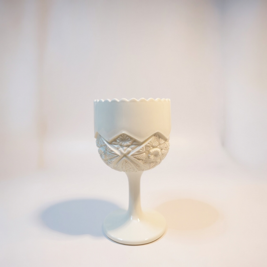 White ceramic cup with decorative pattern on a light background
