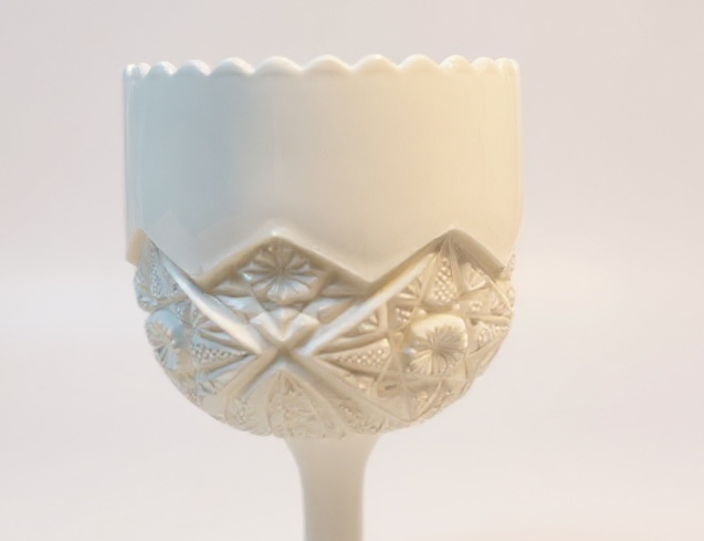 White ceramic cup with decorative pattern on a white background