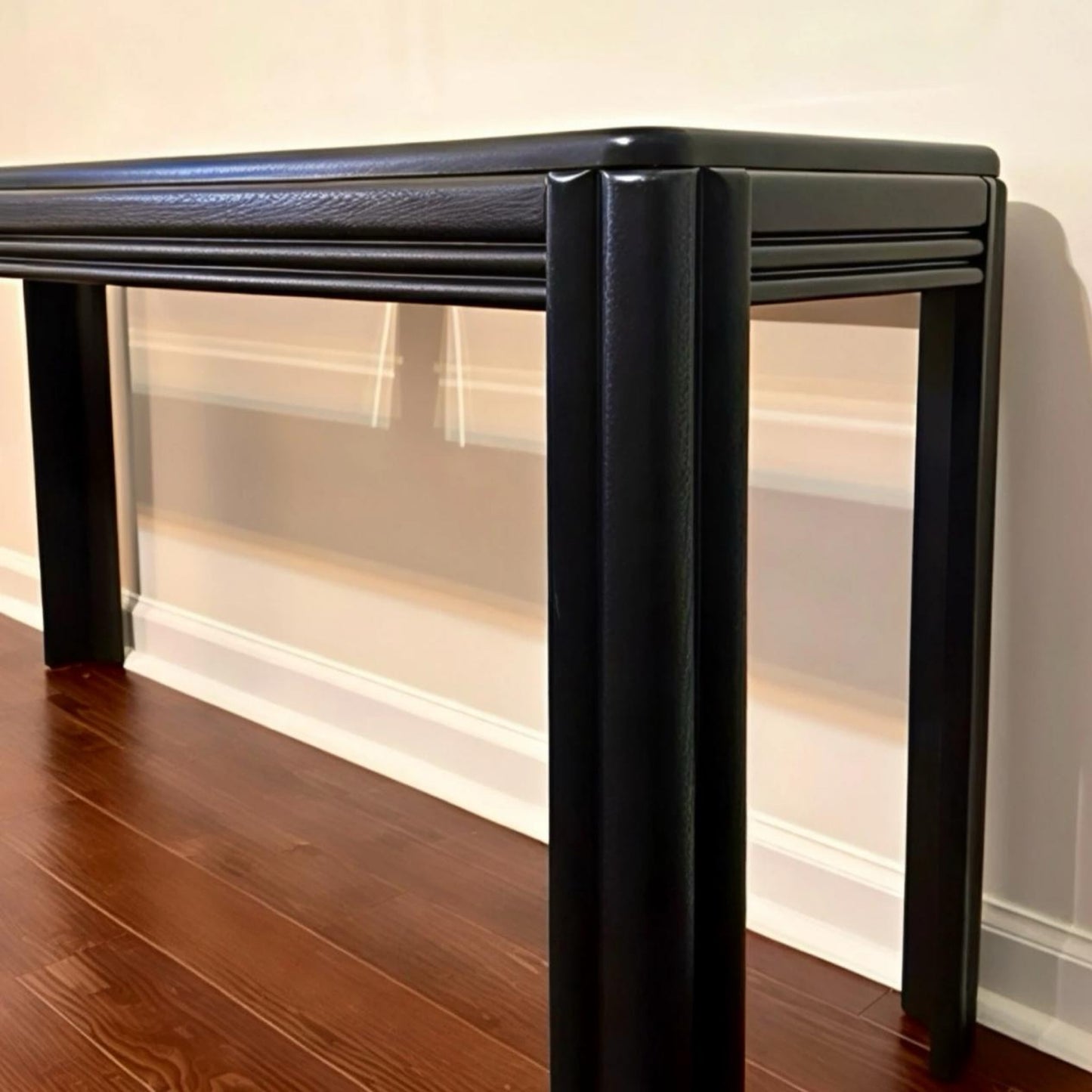 Elegant black console table with textured surface and sleek legs for modern home decor.