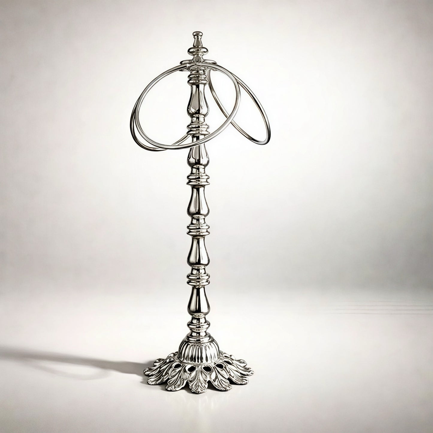Elegant silver ring holder with ornate base, perfect for displaying jewelry in style.