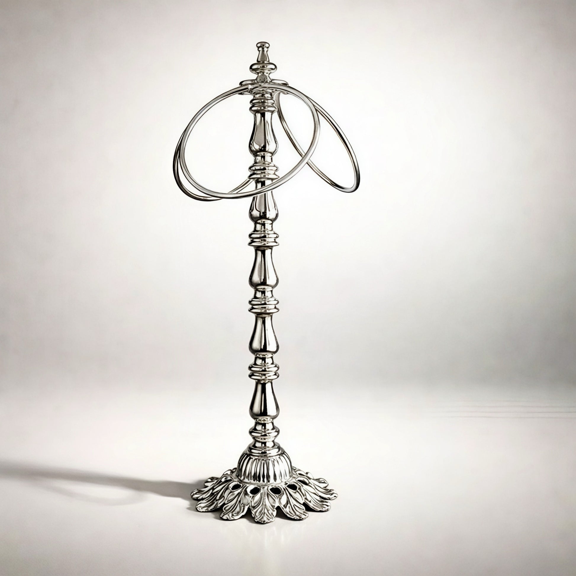 Elegant silver ring holder with ornate base, perfect for displaying jewelry in style.