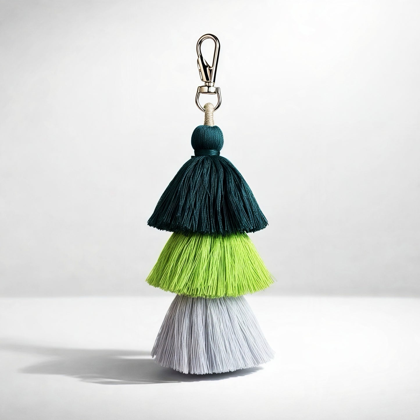 dark green light green grey Multicolored tassel keychain on a white background