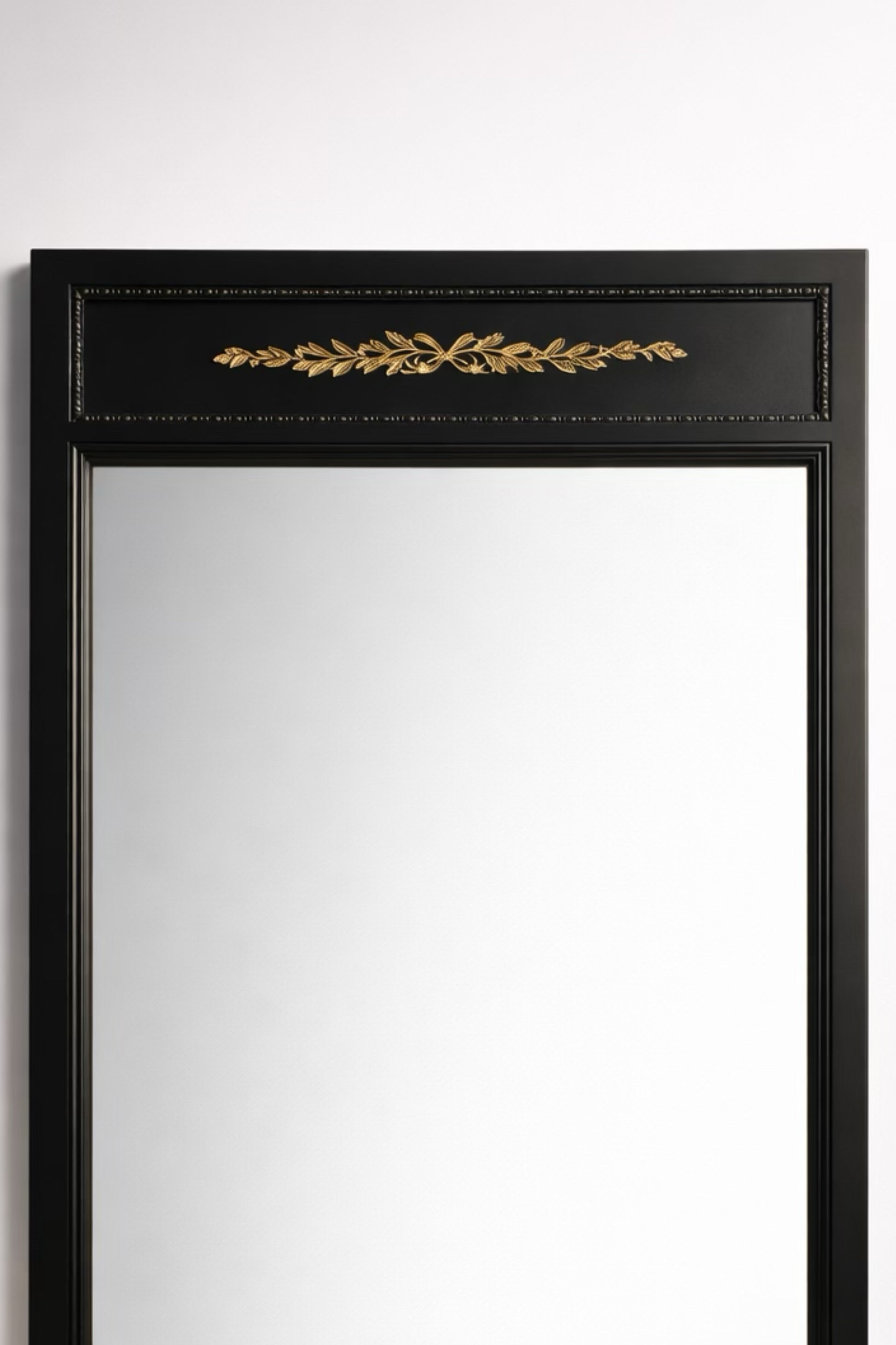 Elegant black wall mirror with gold leaf detailing, perfect for stylish home decor.