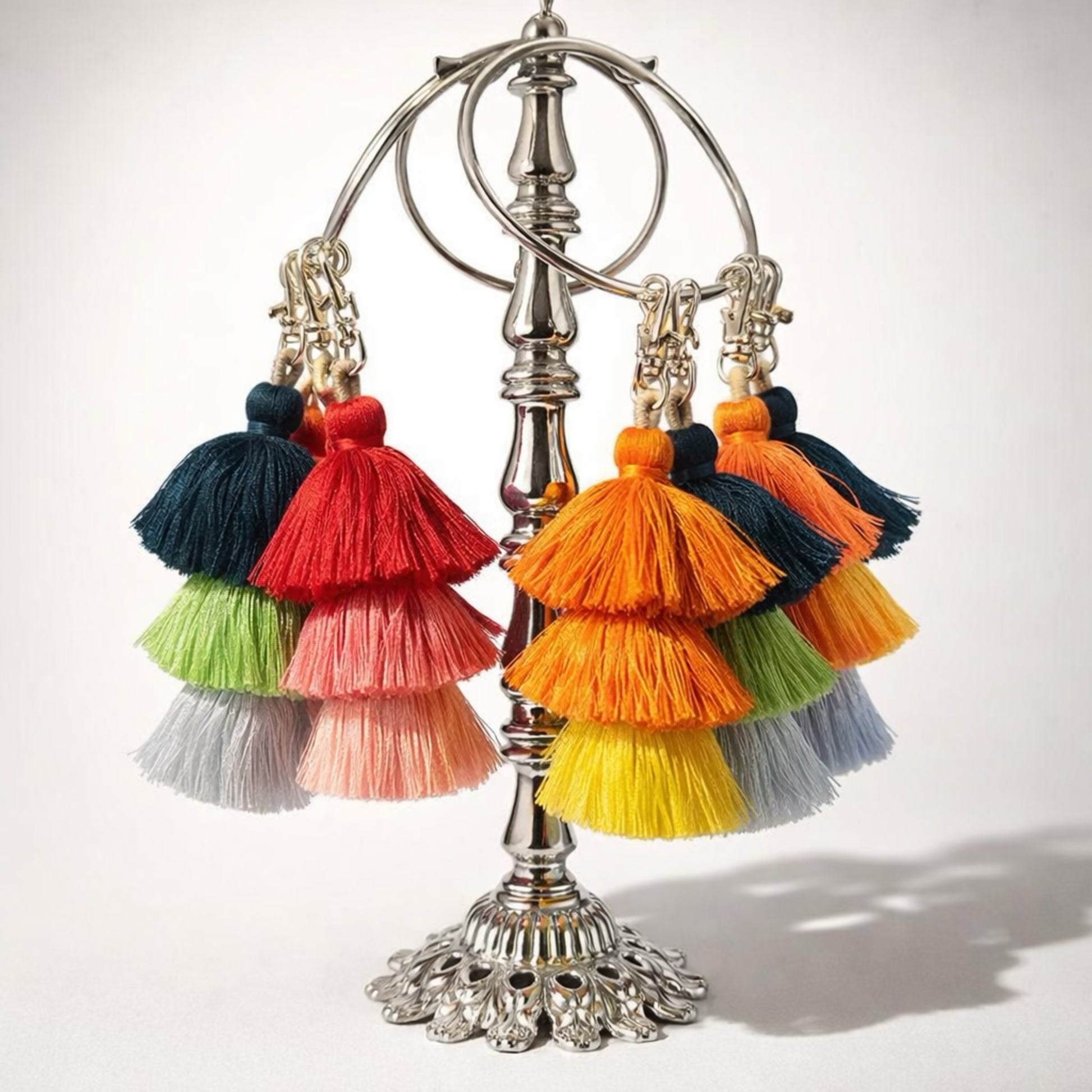 Colorful tassel clip ons on a decorative stand against a white background