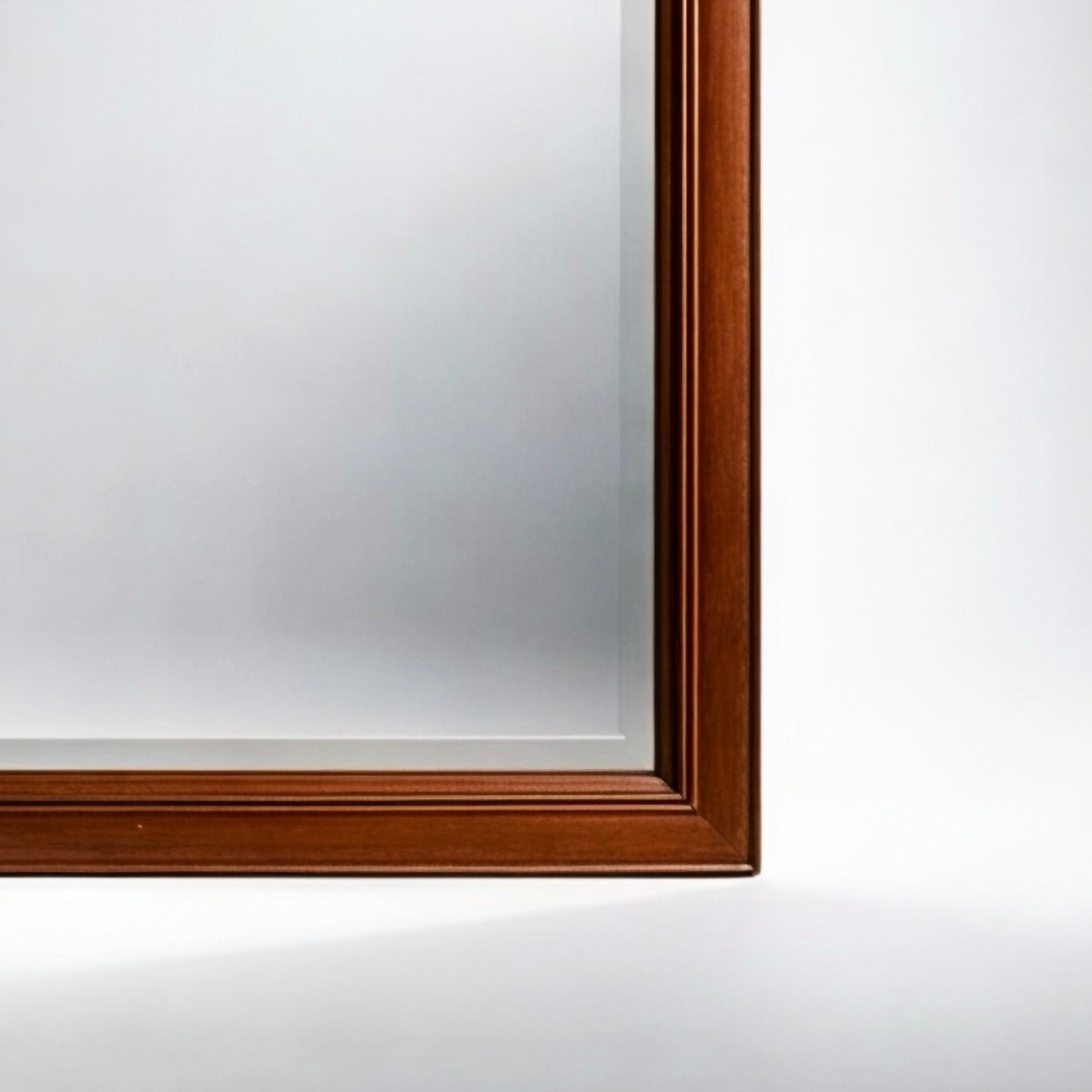 Elegant wooden mirror frame in rich mahogany color with detailed edges, perfect for home decor.